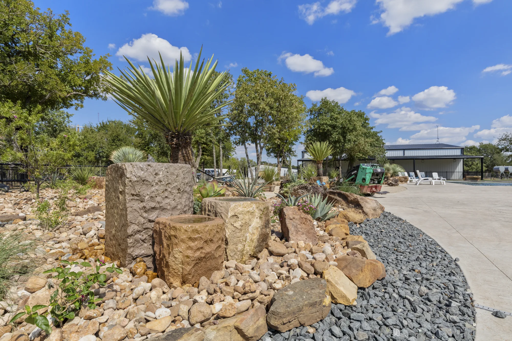 Stacked sandstone boulders with yucca, tan rock and a black rock mulch band