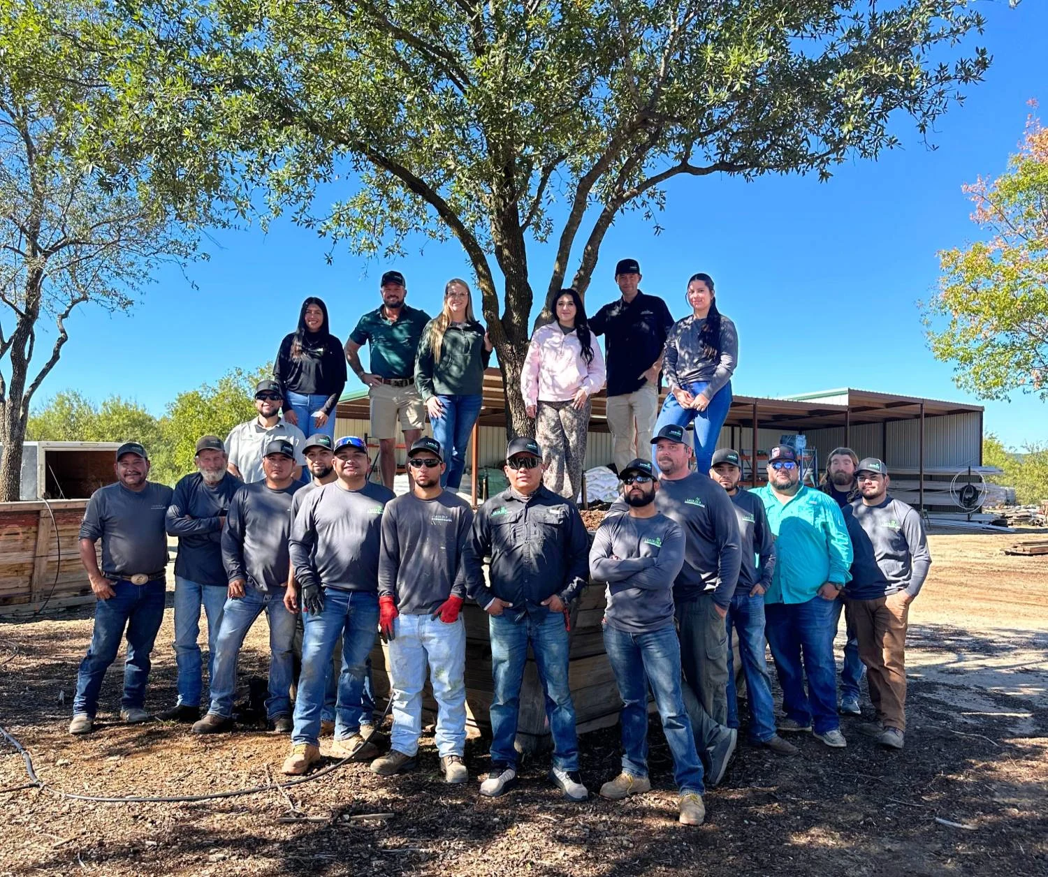 The Let Us Do It Landscaping crew gathered under a live oak at the Graford yard