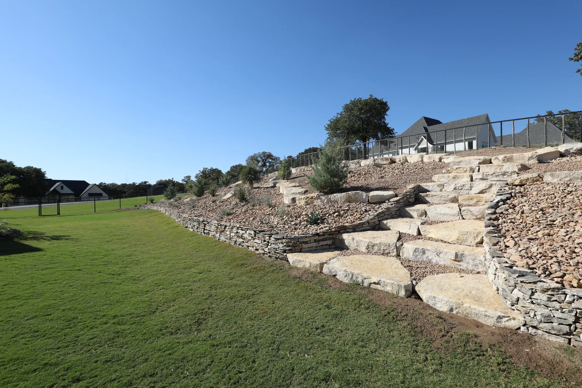 Stacked stone terracing with planted beds worked into the slope