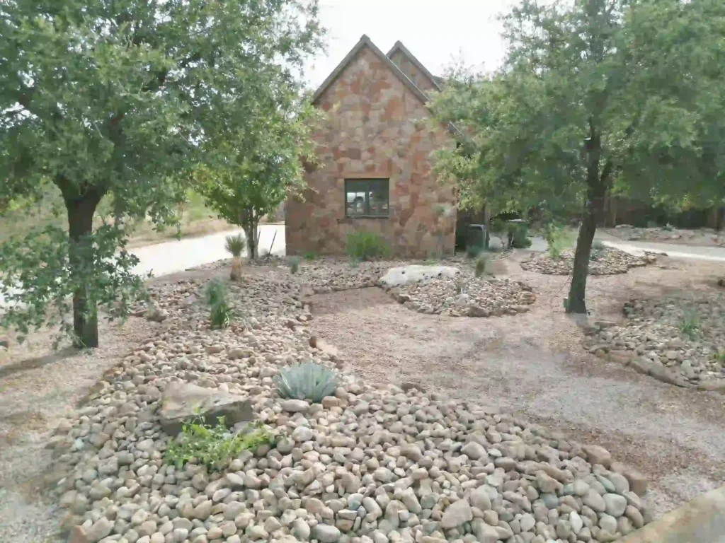 House with rock garden landscaping and trees.